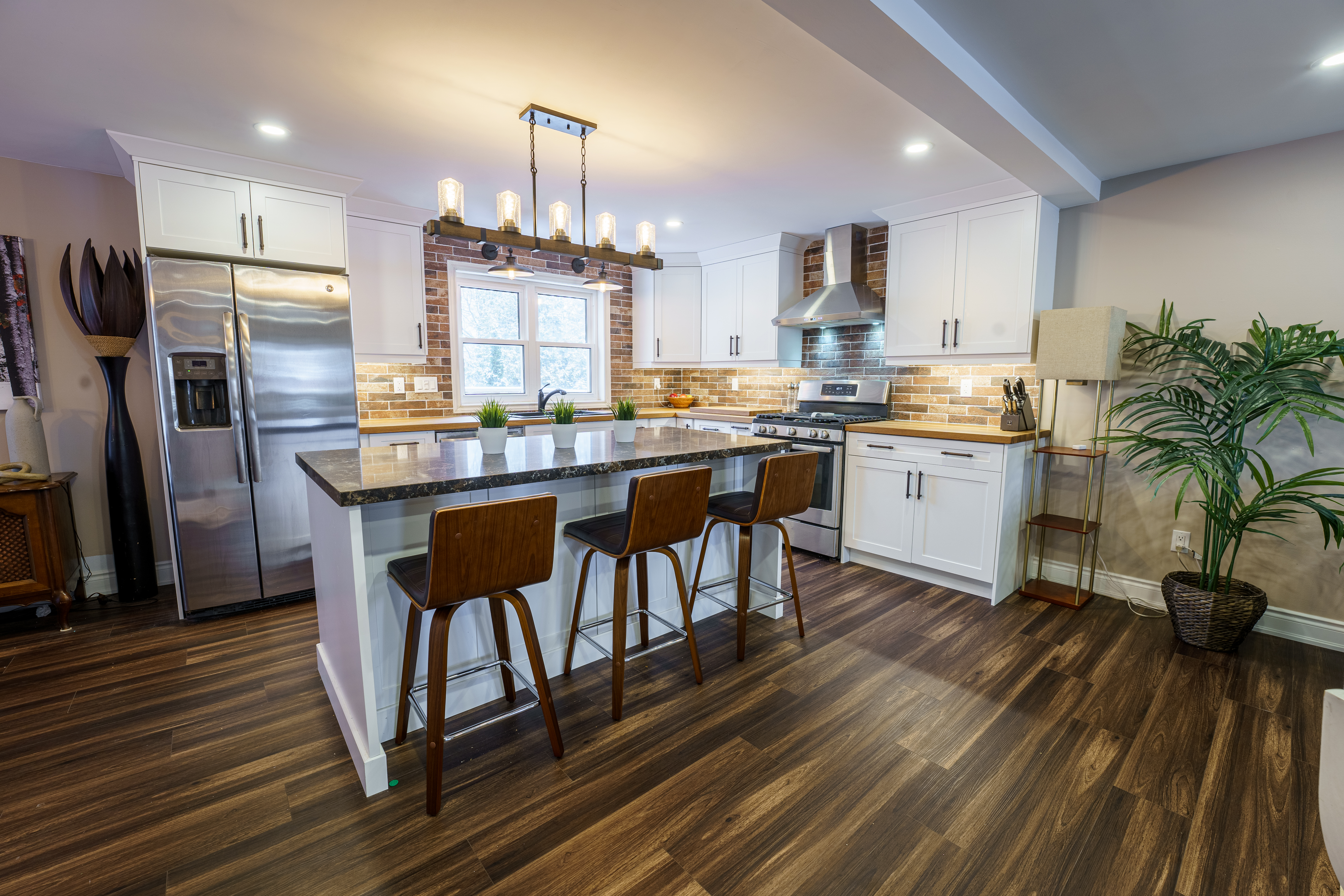 Kitchen renovation with brick backsplash and dark wood floors