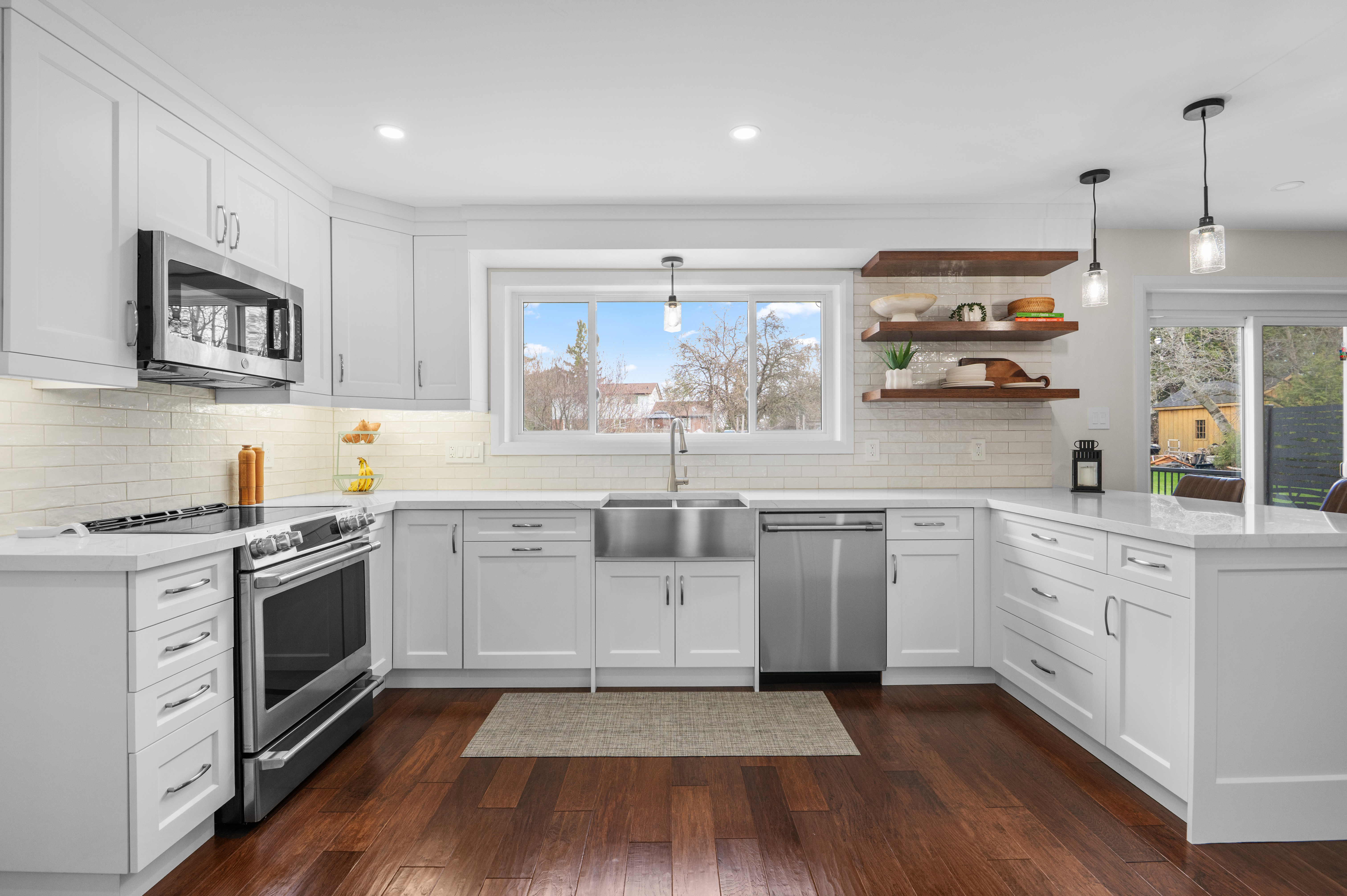 White shaker kitchen with farmhouse sink and dark hardwood floors